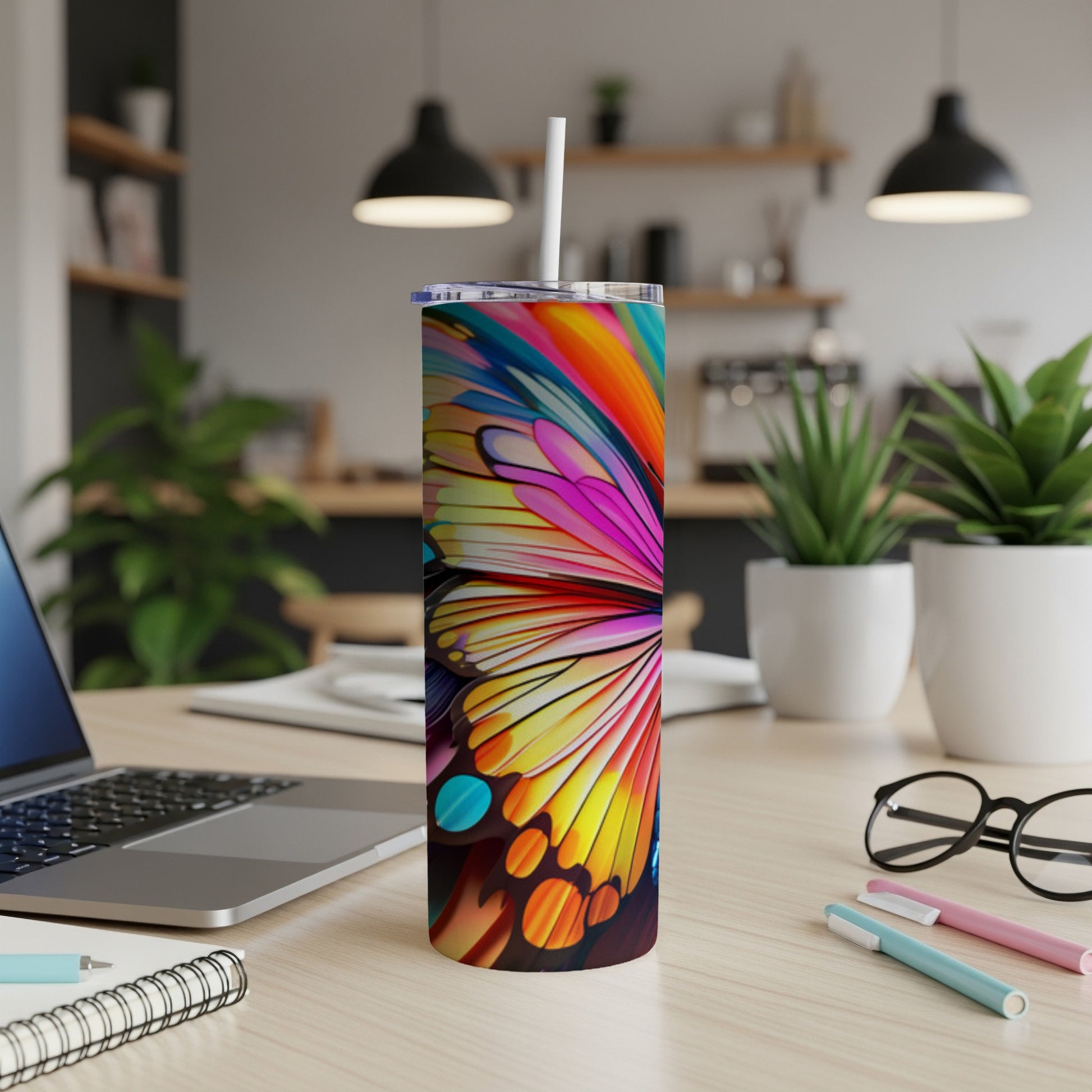Colorful butterfly wing pattern on a white tumbler with a straw.