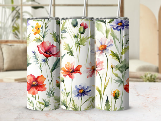 Three tumblers with watercolor floral patterns and a bokeh background.