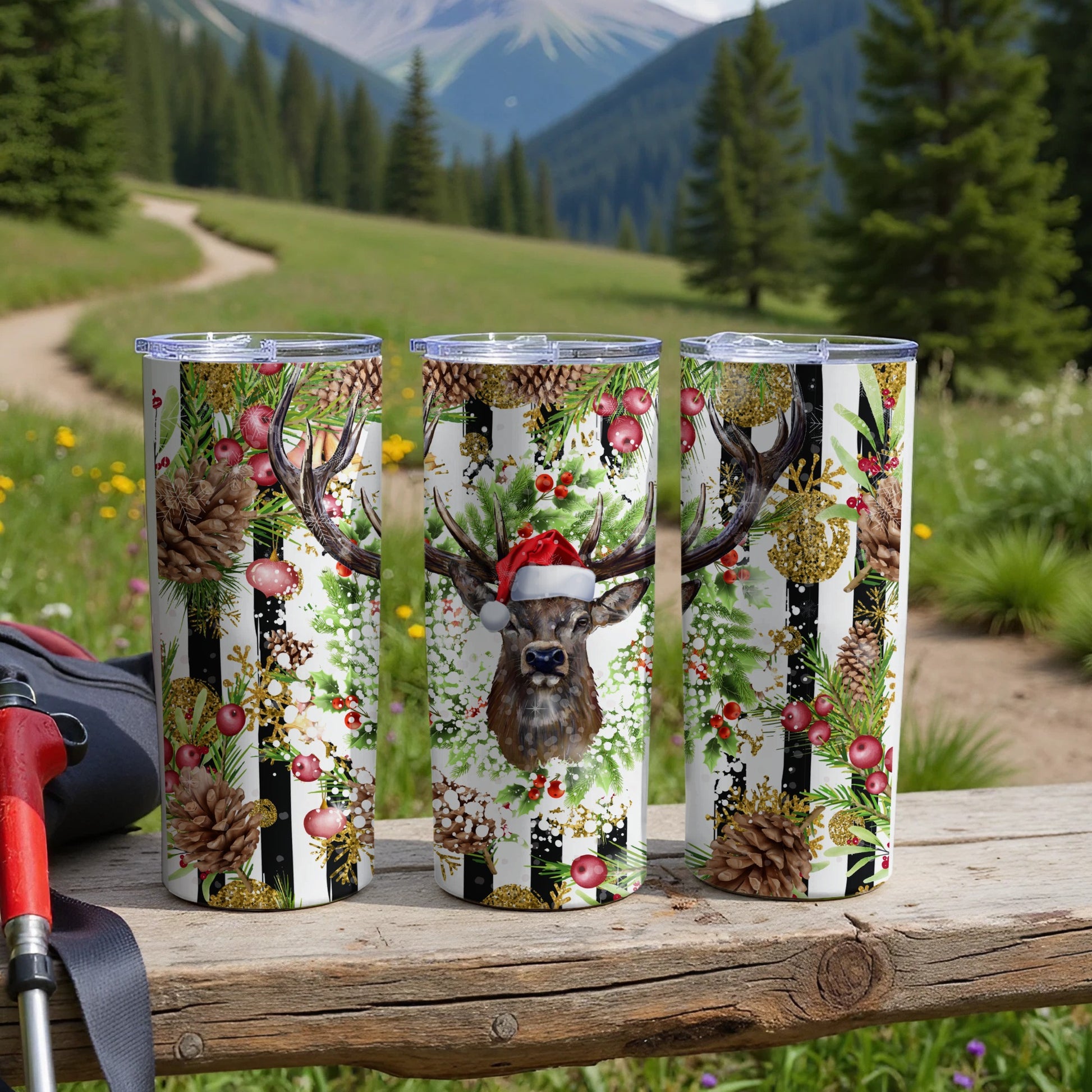 Three tumblers with reindeer and pinecone Christmas designs.