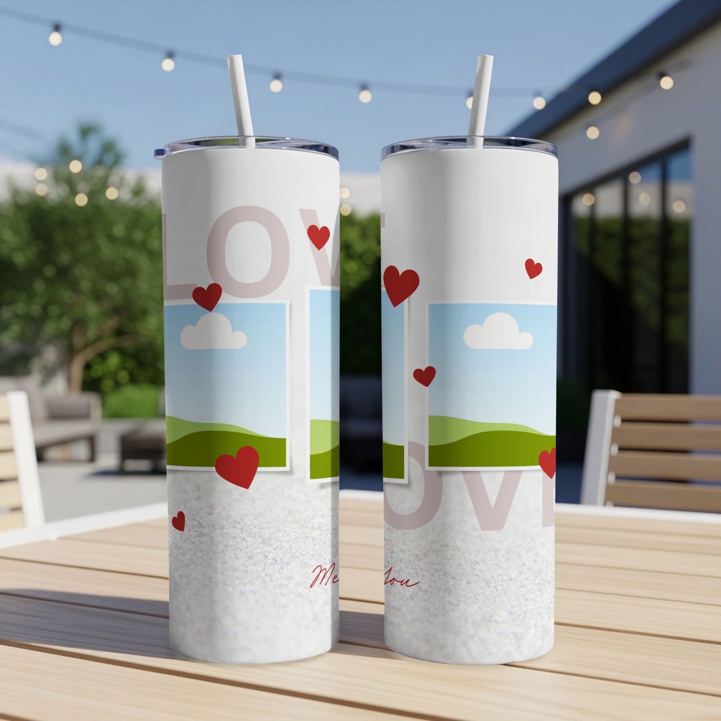 Two white tumblers with red hearts, landscapes, and "love" text on a table.