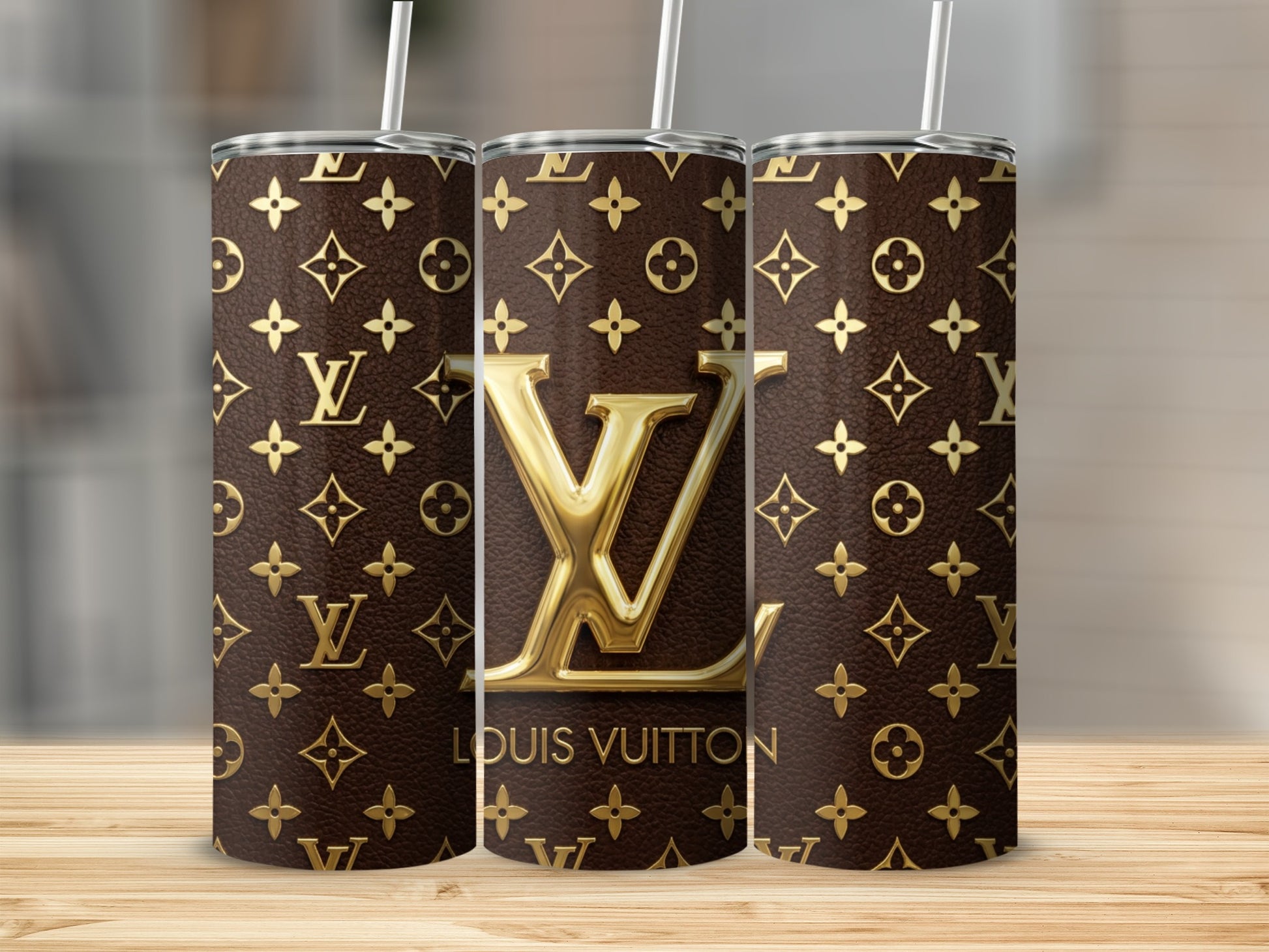 Three patterned tumblers with gold LV logo and text on brown background