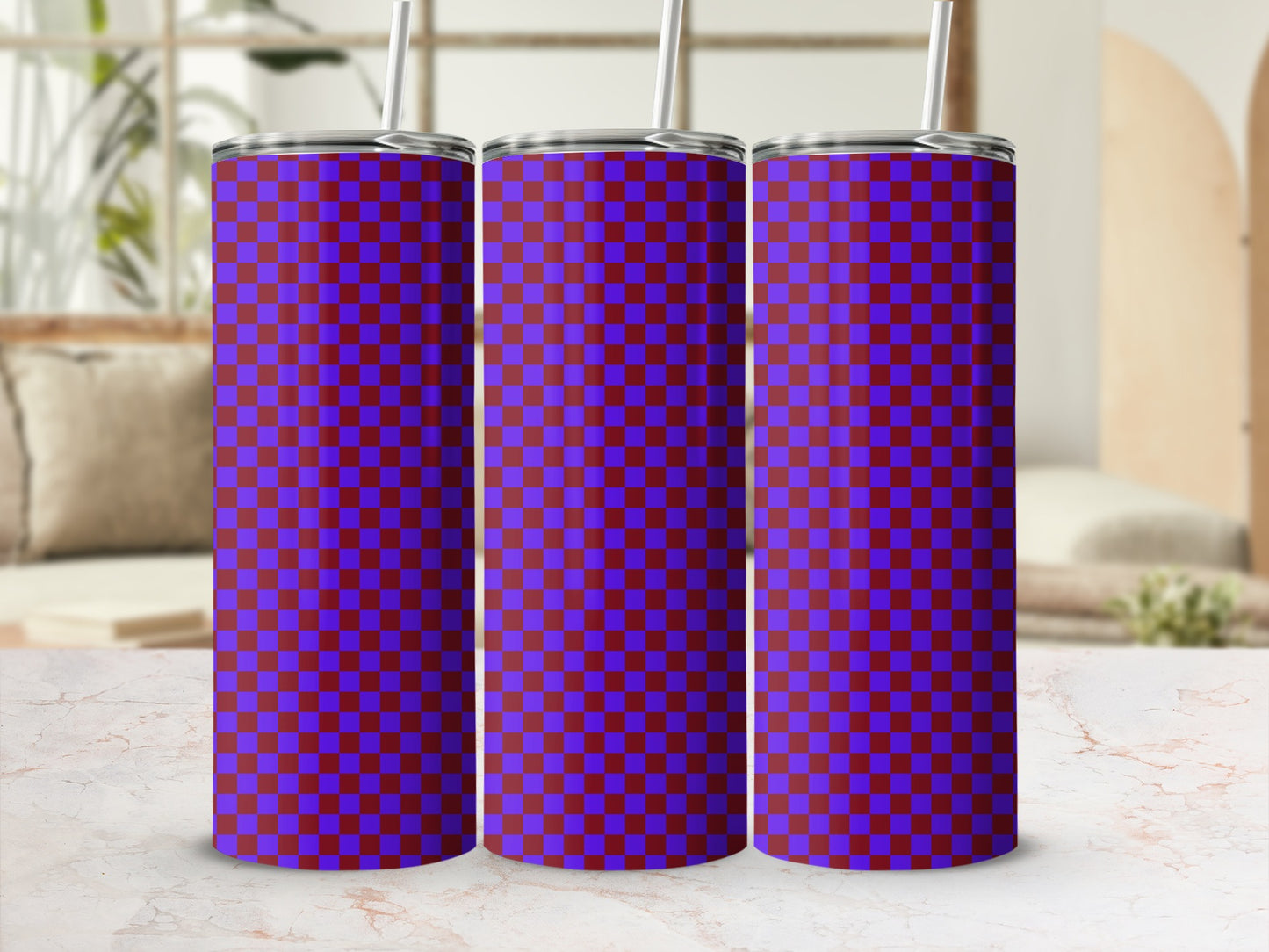 Three purple and blue checkered tumblers with straws on a marble surface.