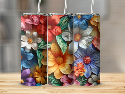 Three floral tumblers with colorful flower designs on a wooden surface.