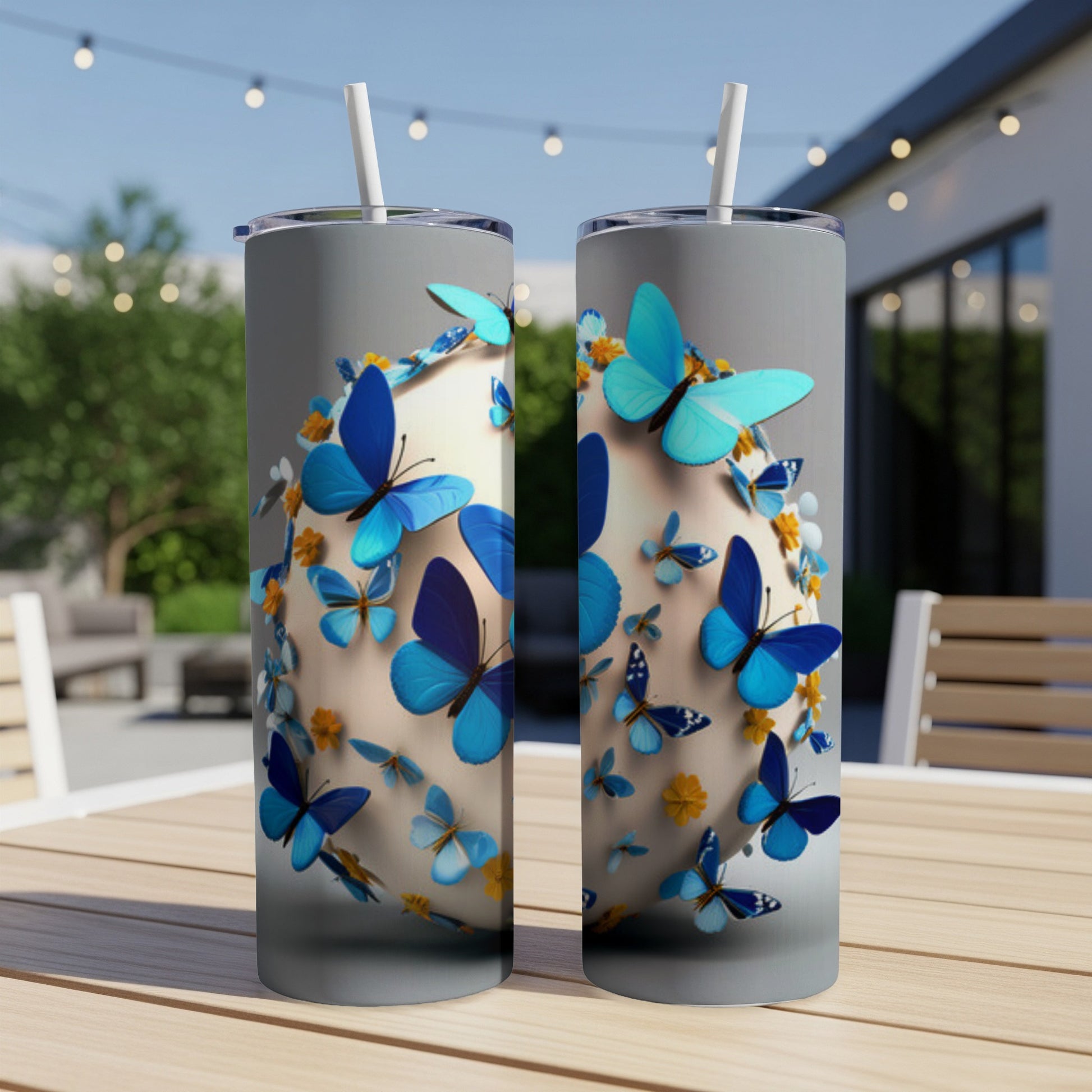 Two light blue tumblers with butterflies and flowers, on a wooden table.