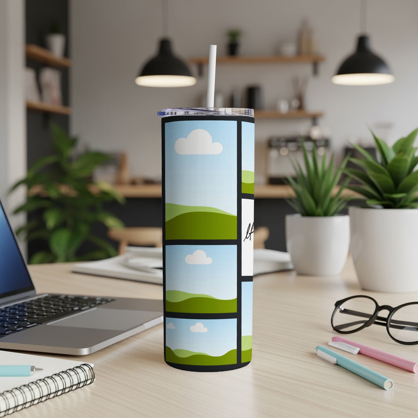 Tumbler with landscape photo collage and white straw on a wooden desk.