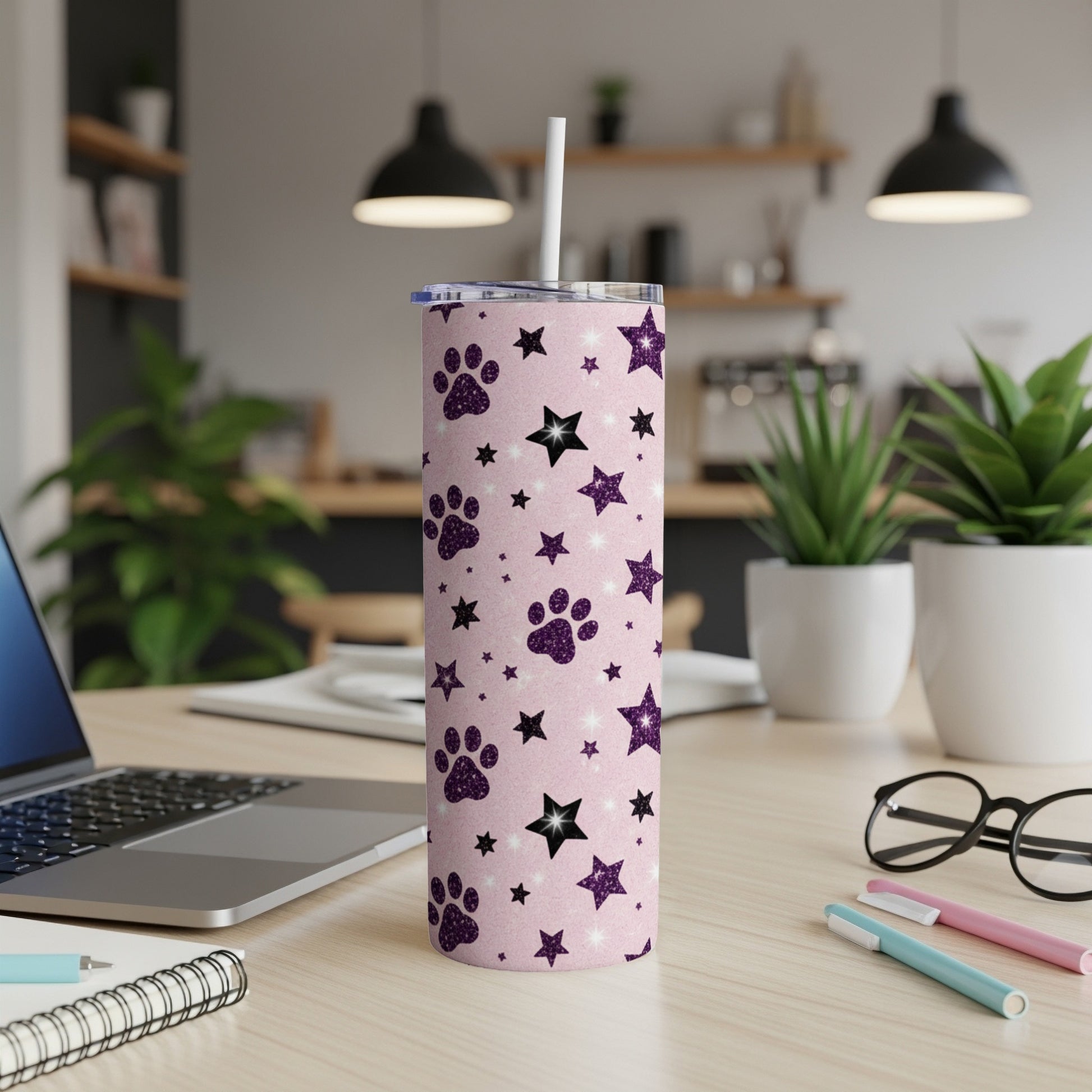 Pink tumbler with paw prints and stars, and a straw.