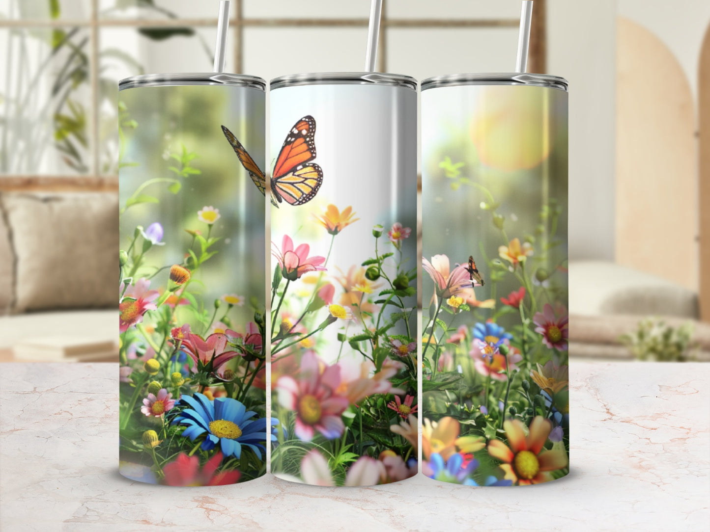 Three tumblers with colorful floral and butterfly designs on a bright background.