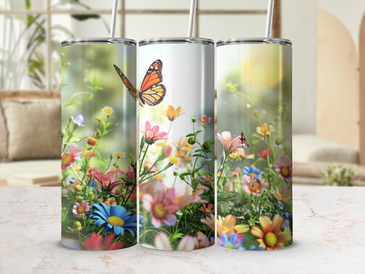 Three tumblers with colorful floral and butterfly designs on a bright background.