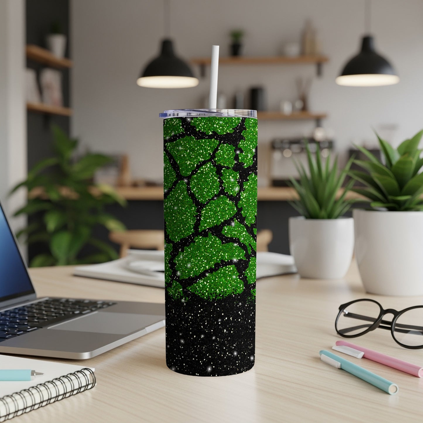 Green glitter tumbler with black abstract pattern and white straw.