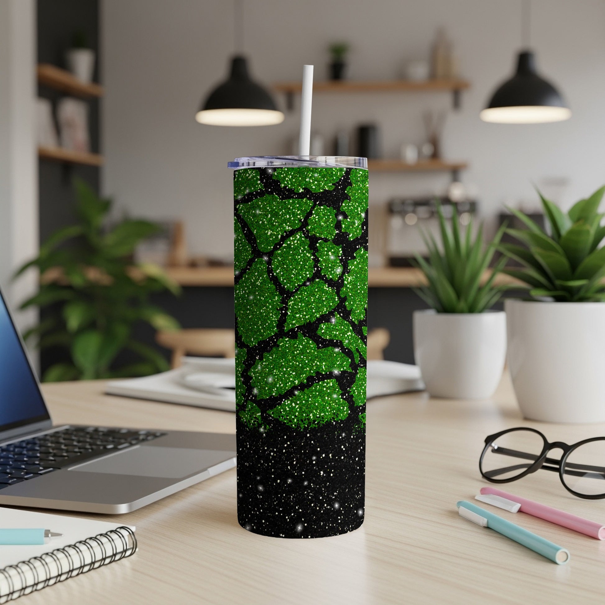 Green glitter tumbler with black abstract pattern and white straw.