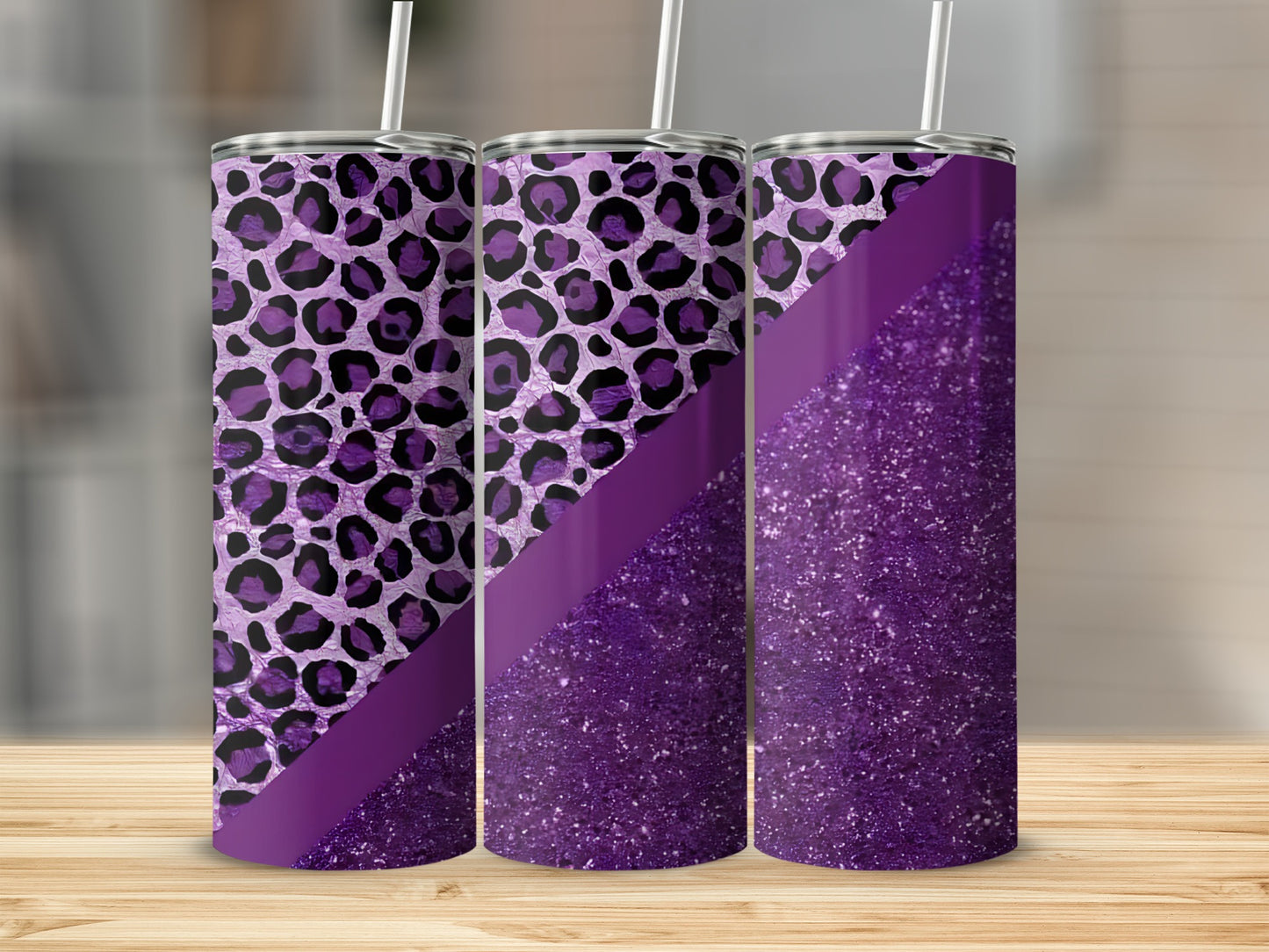 Purple leopard print and glitter tumbler with straw on wooden surface.