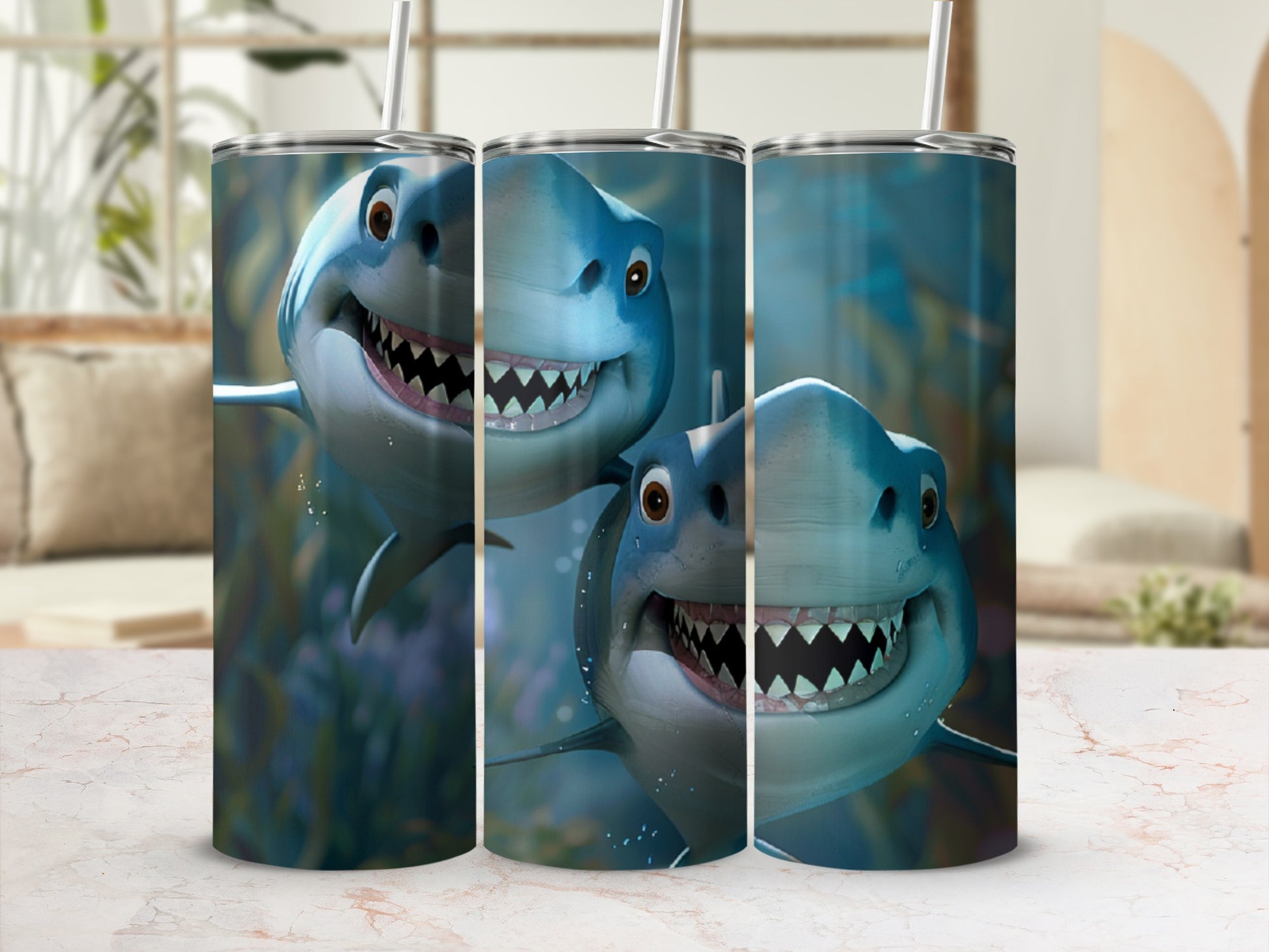 Three tumblers decorated with cartoon sharks smiling, with straws.