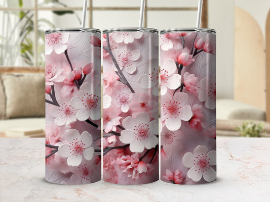Pink cherry blossoms on three tall tumblers with straws.