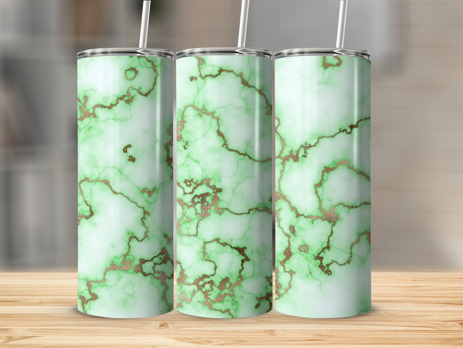 Three green marble tumblers with gold veining on a wooden surface.