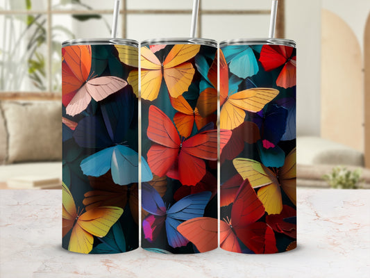 Three tumblers with colorful butterfly patterns on a marble surface.