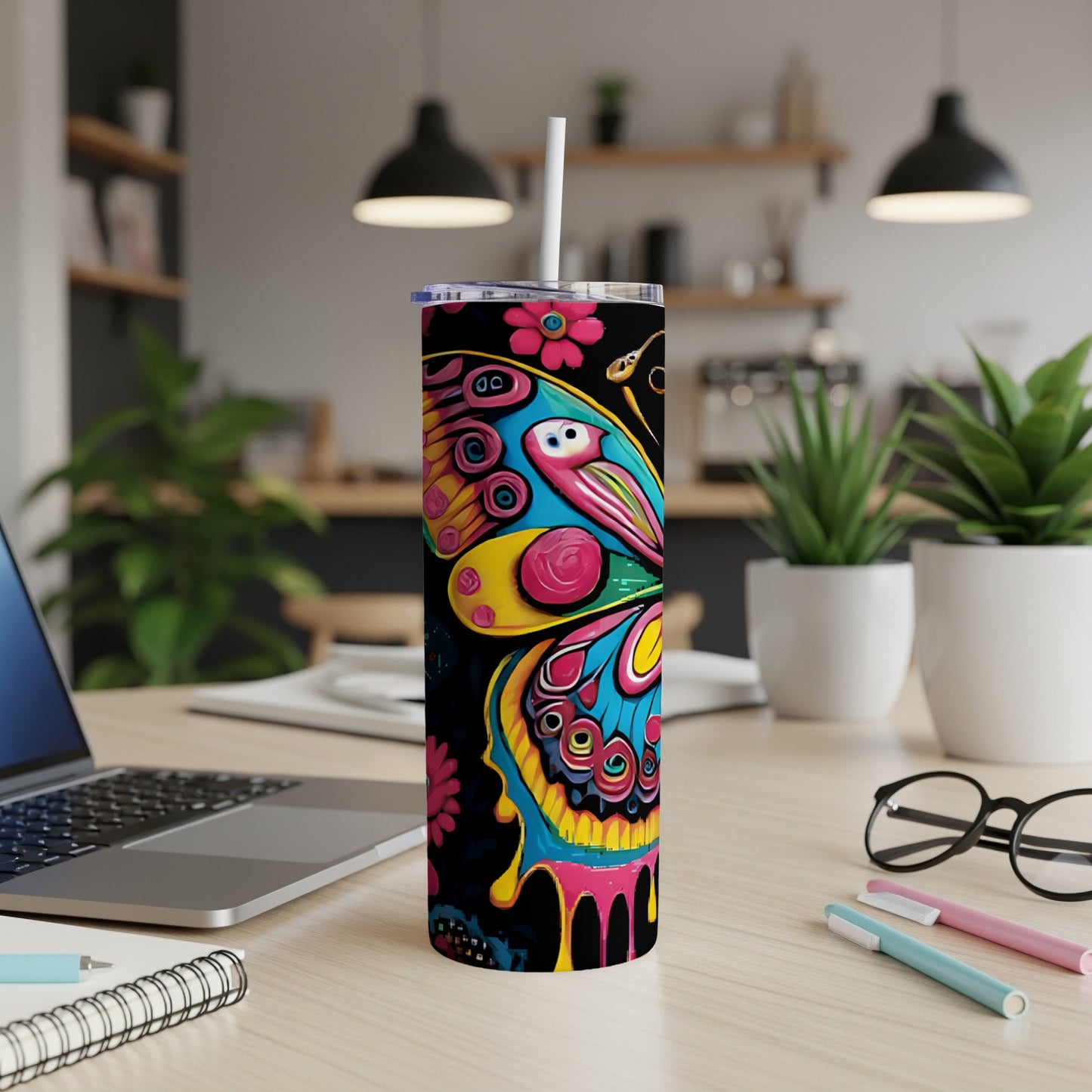 Colorful butterfly and floral design on a black skinny tumbler with straw.