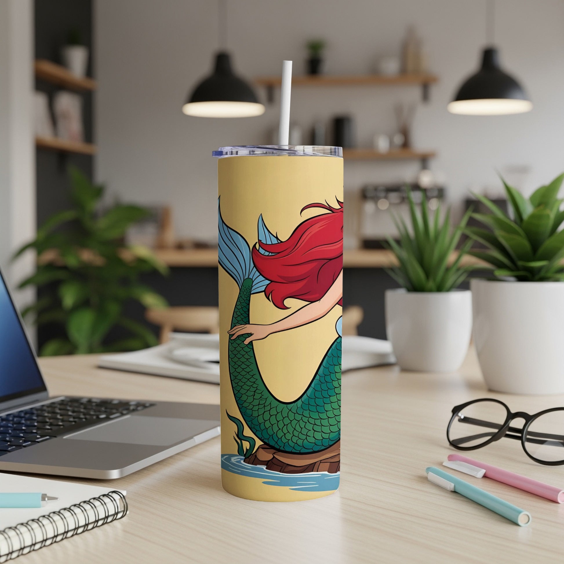 Yellow tumbler with Ariel the mermaid illustration and white straw.