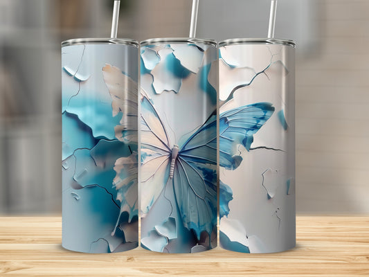 Three blue and white butterfly tumblers with straws on a wooden surface.