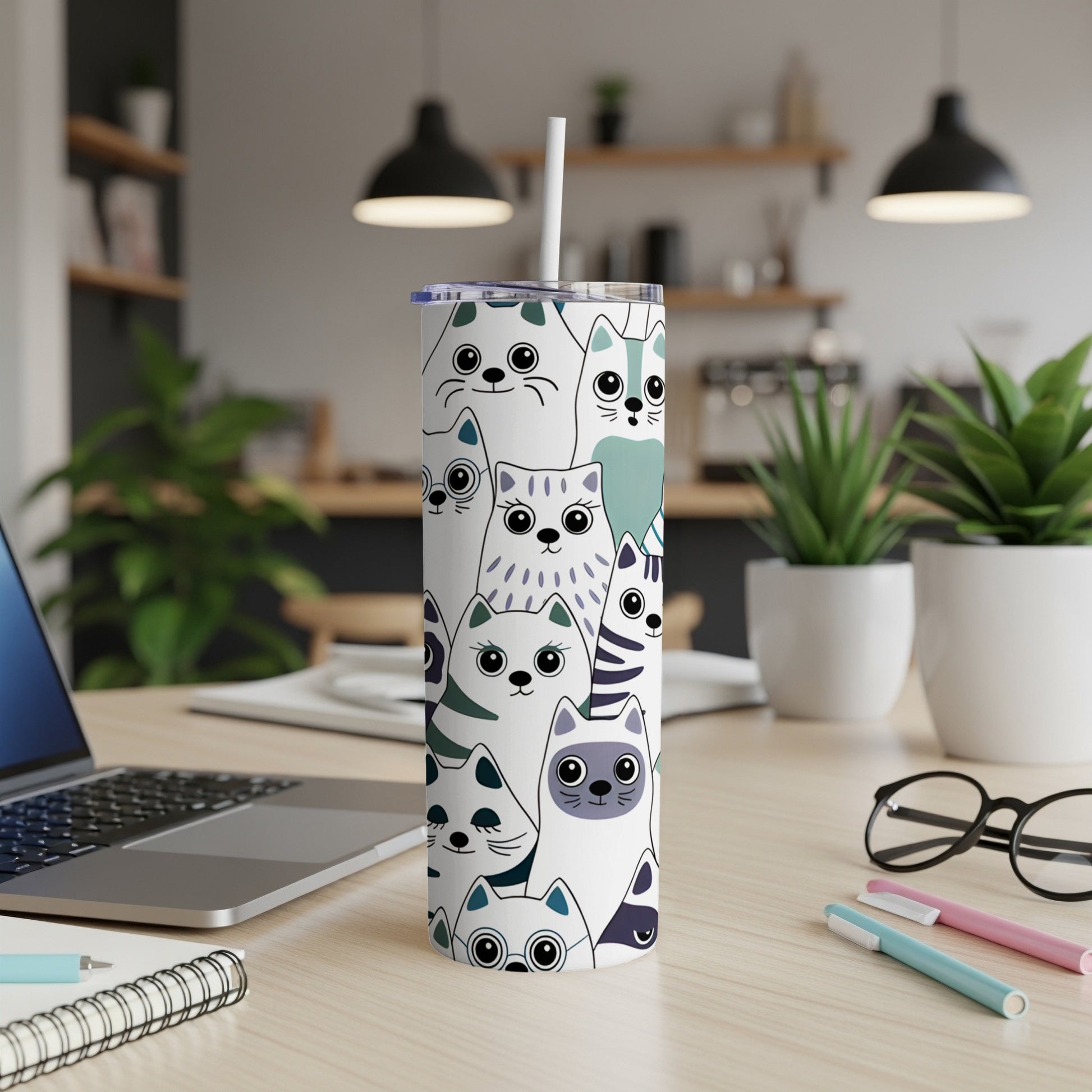White tumbler with a repeating pattern of cartoon cats in various colors.