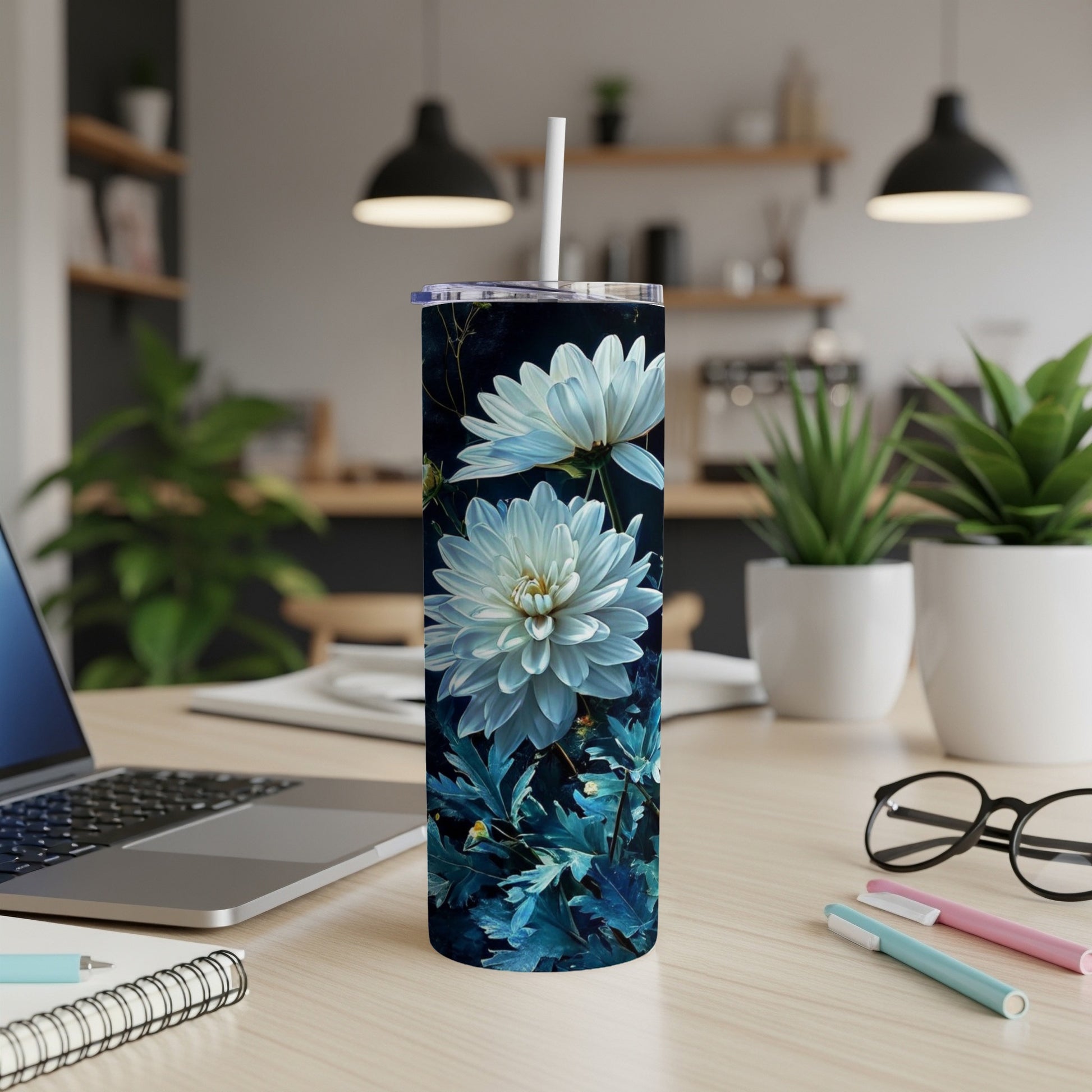 White dahlia flowers and dark blue leaves on a slim tumbler.