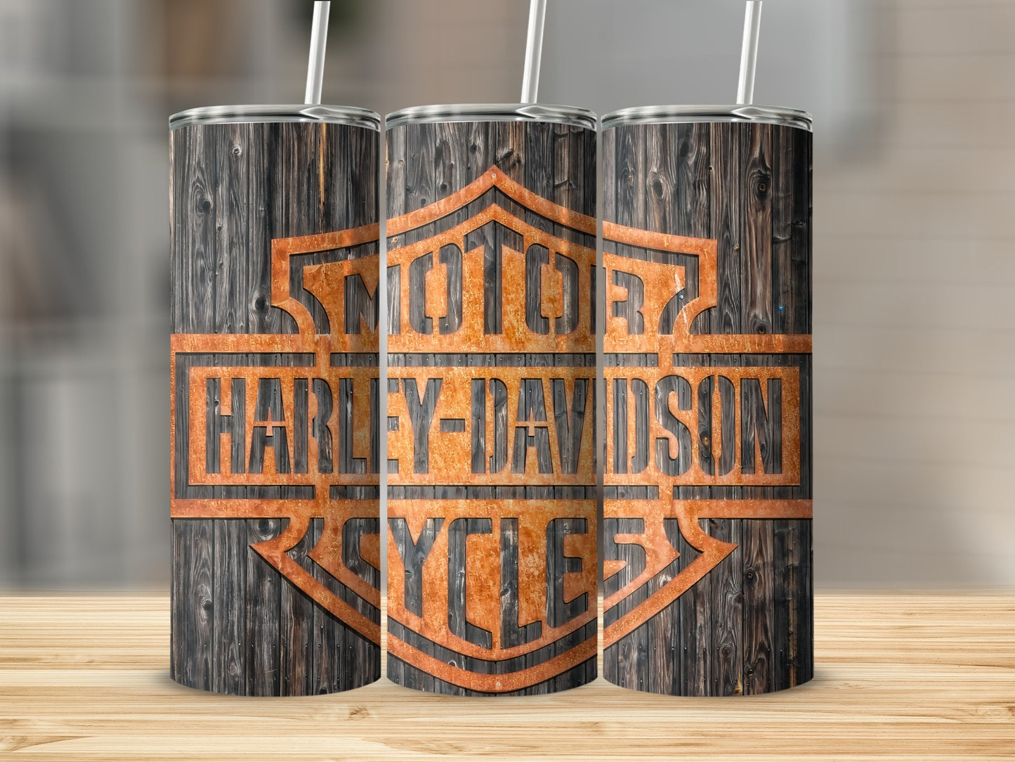 Three stainless steel tumblers with Harley-Davidson logo printed on weathered wood background.