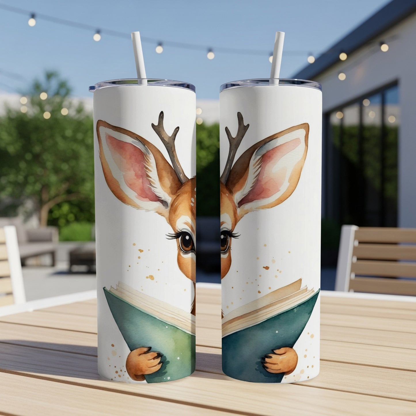 Deer with antlers reading a book on a white tumbler.