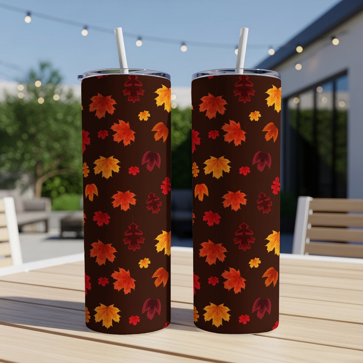Two tumblers with a repeating pattern of colorful autumn leaves on a dark background.