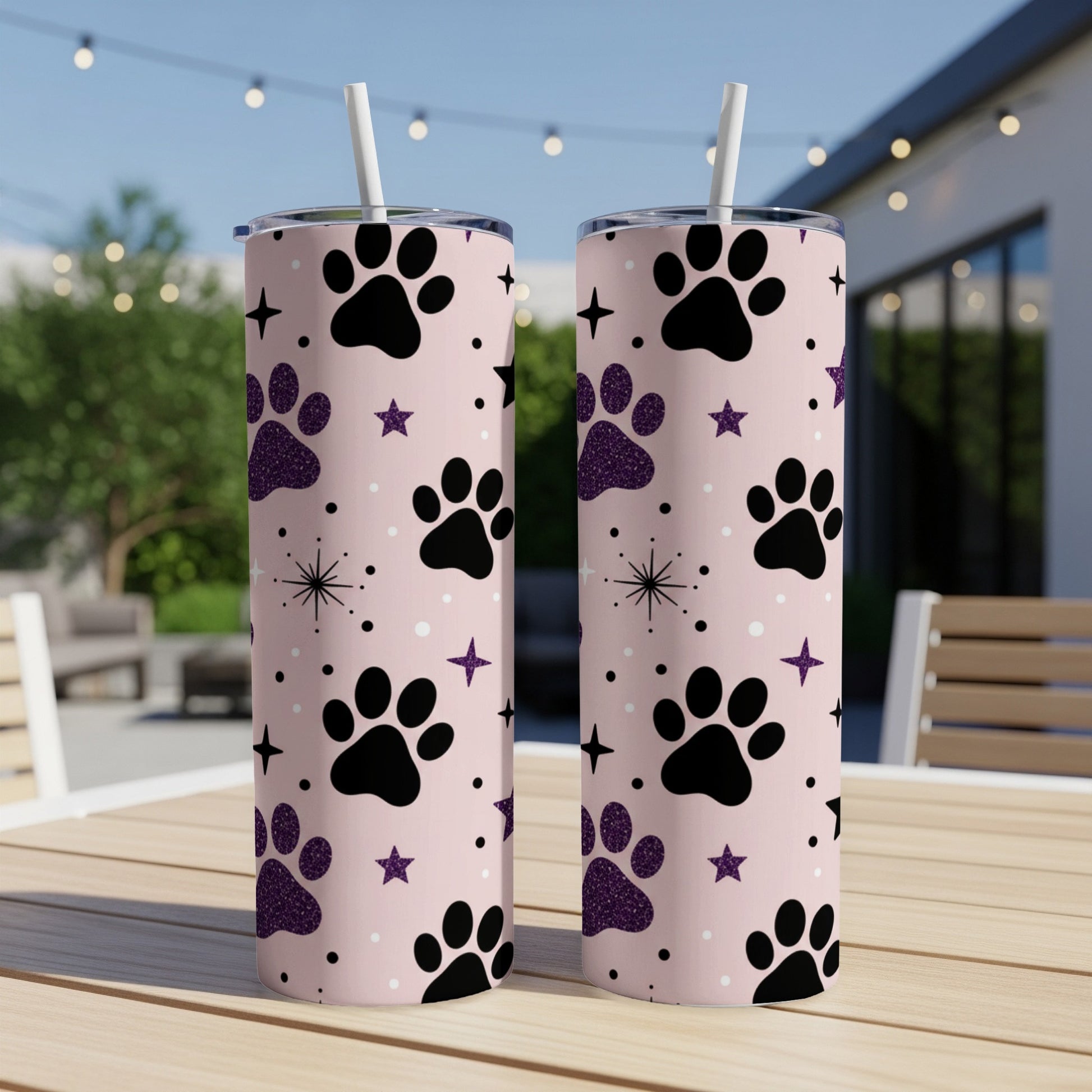 Two tall tumblers with a pink background and black paw print pattern.