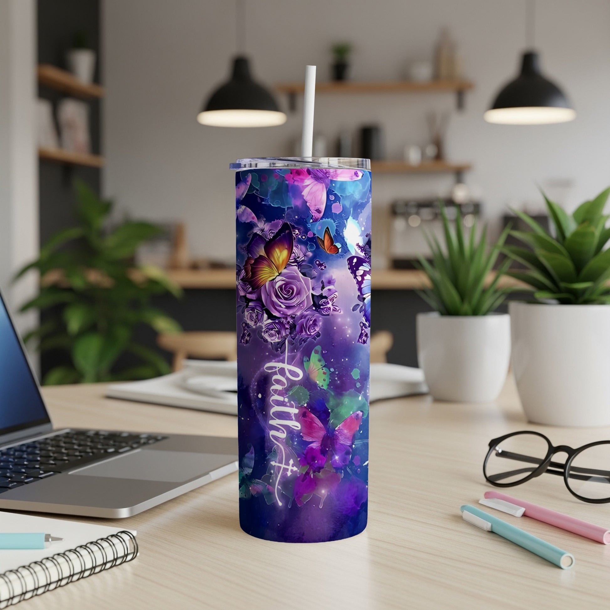 Purple floral tumbler with "Faith" text, a white straw, on a desk.