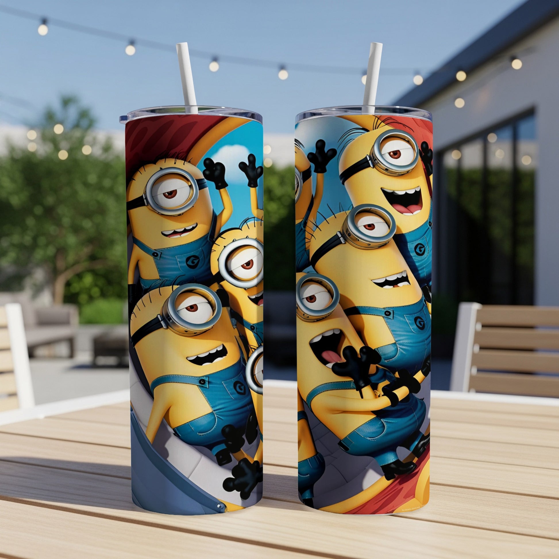 Two Minions tumblers with straw displaying cheerful Minion characters on a table.