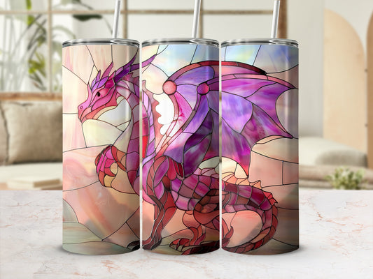 Pink stained glass dragon tumbler with straw on marble surface.