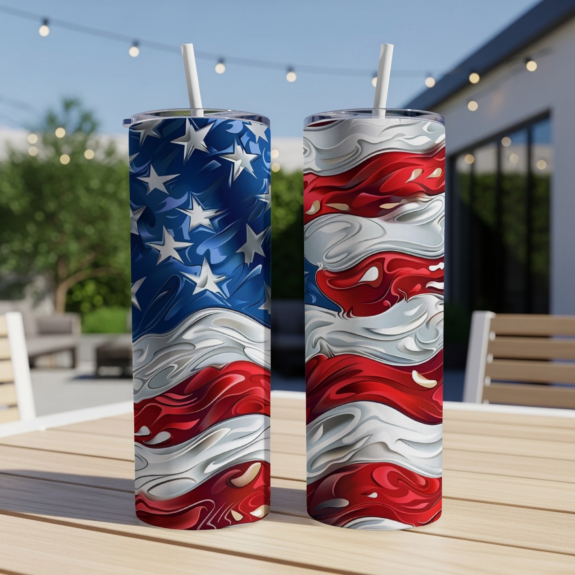 Two tall tumblers with patriotic American flag design on a table outdoors.