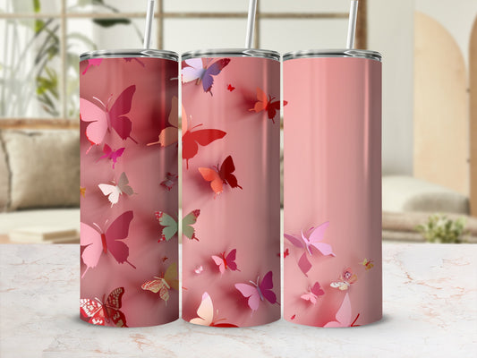 Three pink tumblers with colorful butterfly designs and straws.