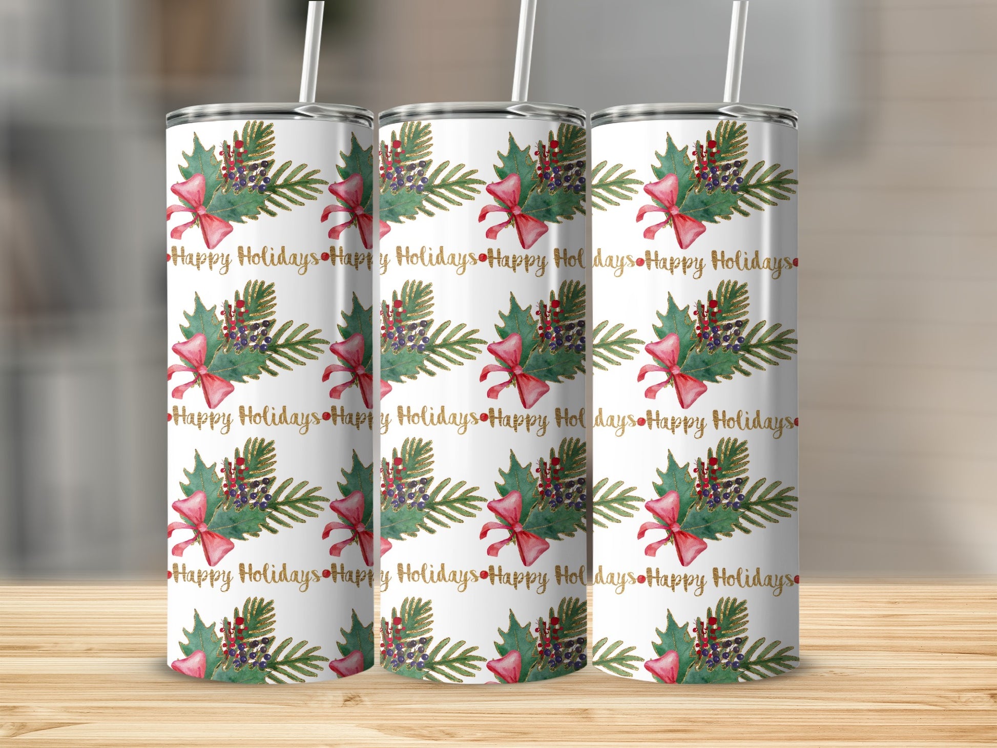 Three tumblers with a "Happy Holidays" pattern featuring bows and greenery.