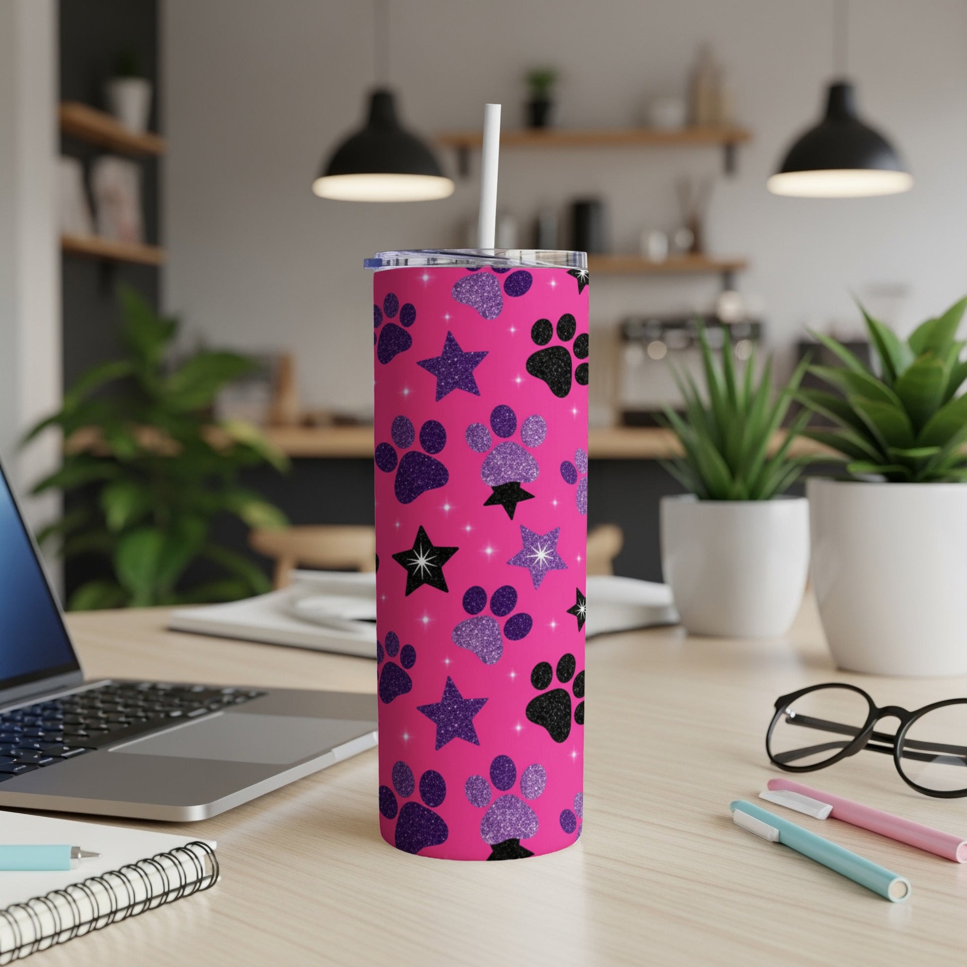 Pink tumbler with glitter paw prints and stars, and a white straw.