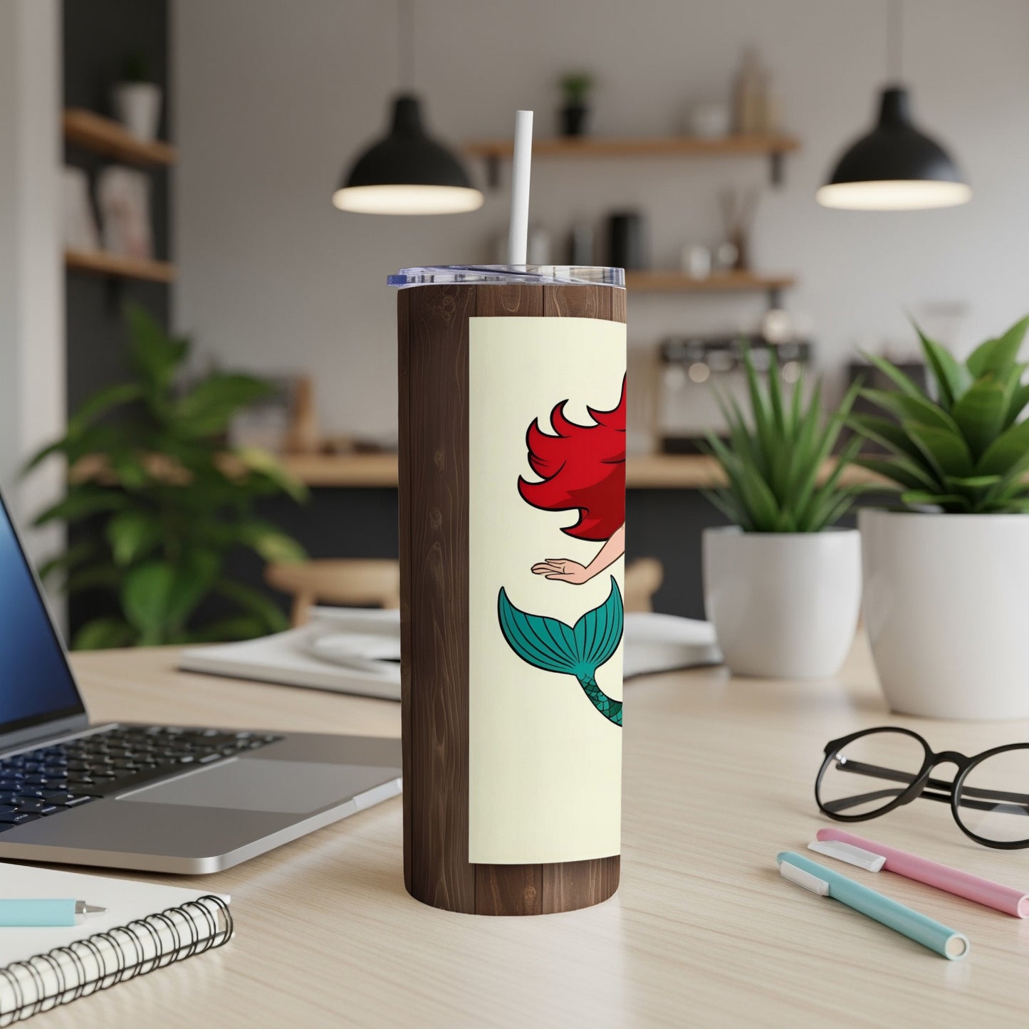Ariel the mermaid on a wooden tumbler with a white straw.