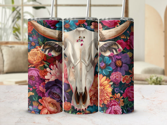 Floral cow skull tumbler with straw against a blurred background.