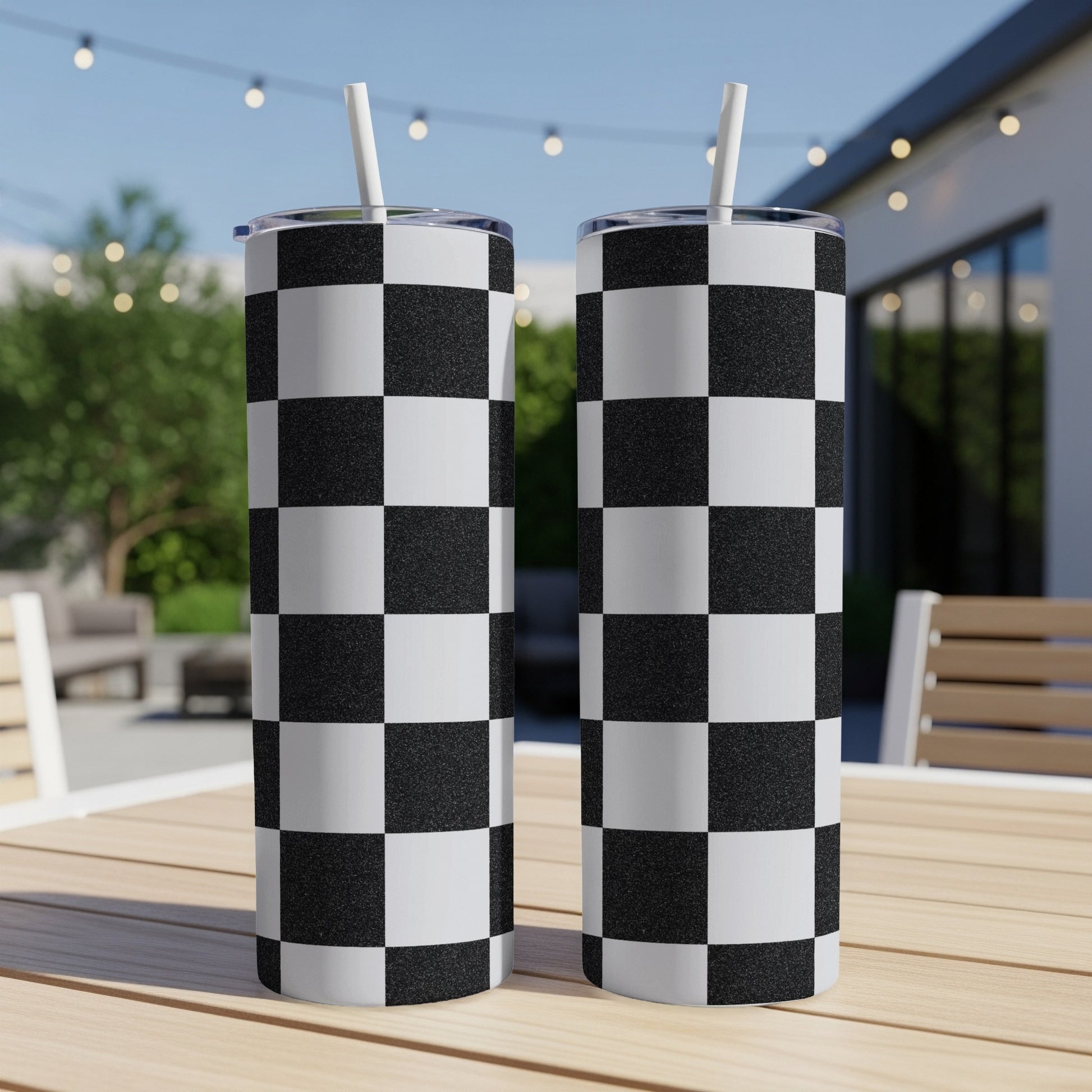 Two tumblers with black and white checkerboard pattern, outdoors.