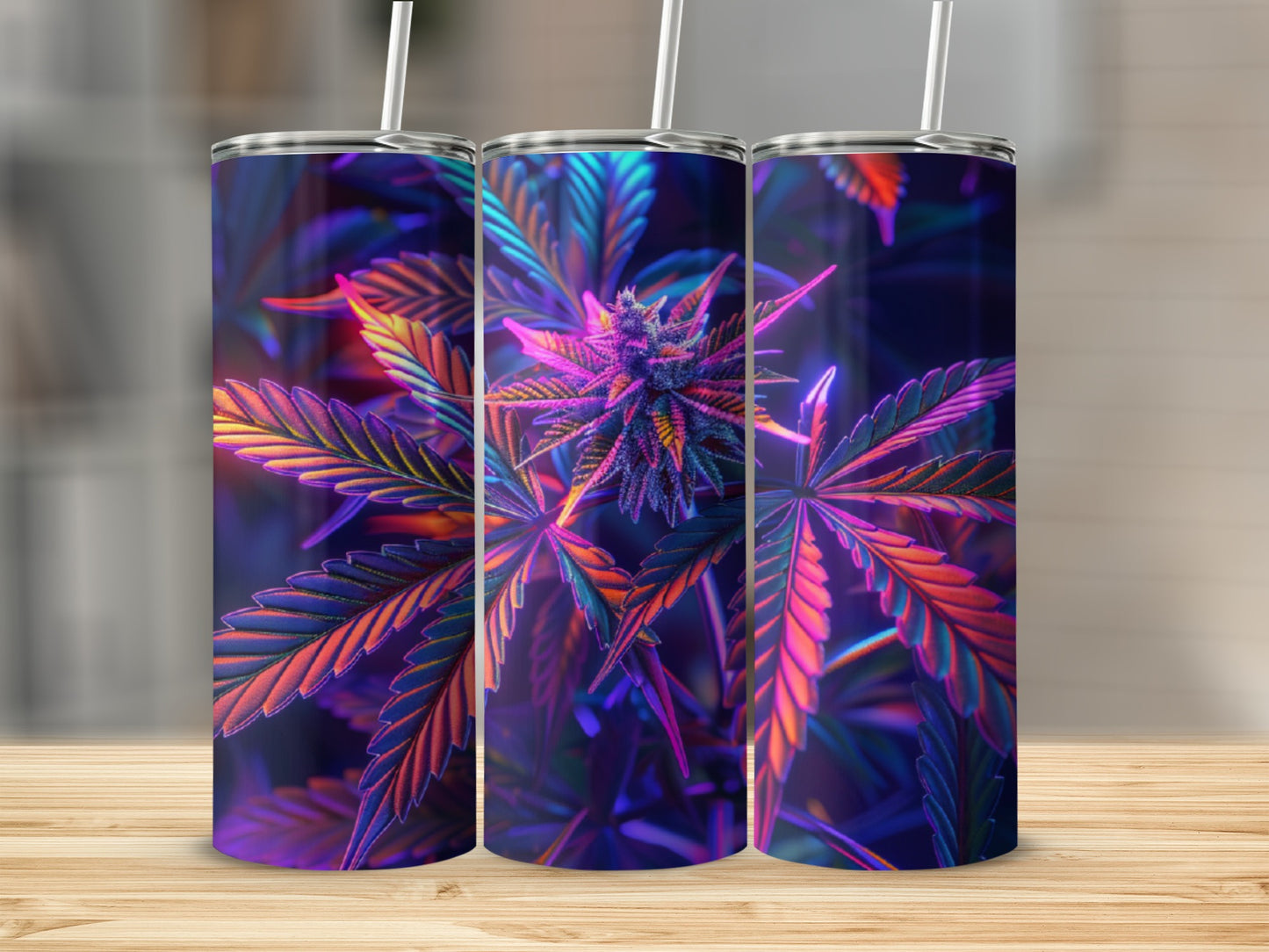 Three tumblers with colorful cannabis leaf design on wooden surface.
