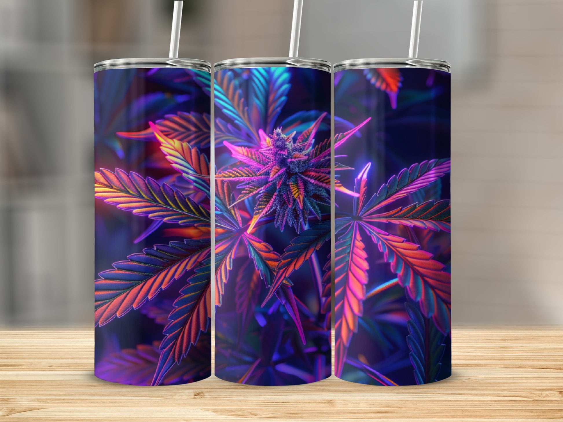 Three tumblers with colorful cannabis leaf design on wooden surface.