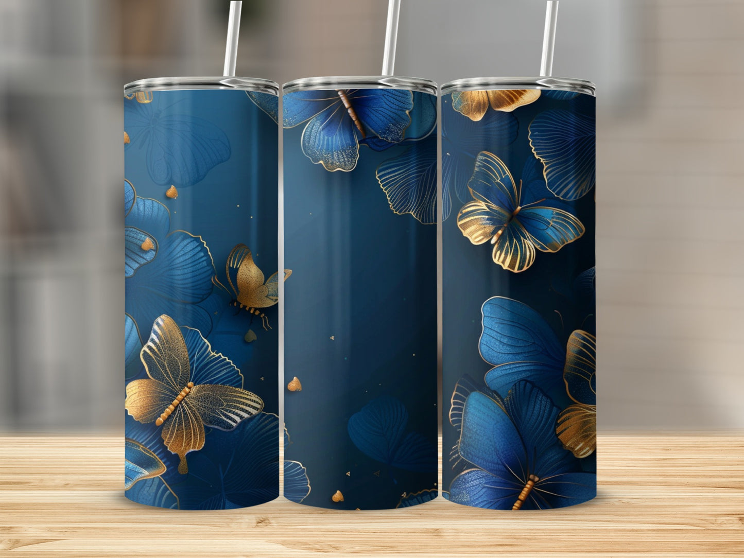 Three blue tumblers with gold butterfly and floral designs.