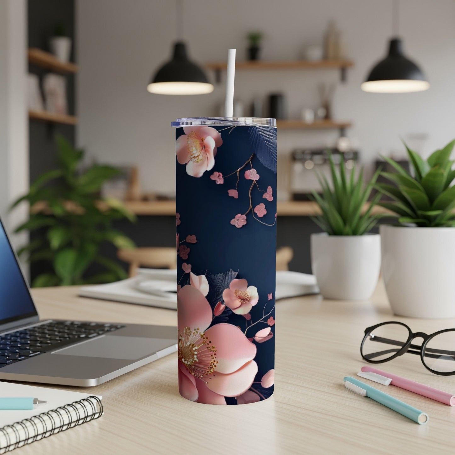 Navy blue tumbler with pink floral design and white straw.