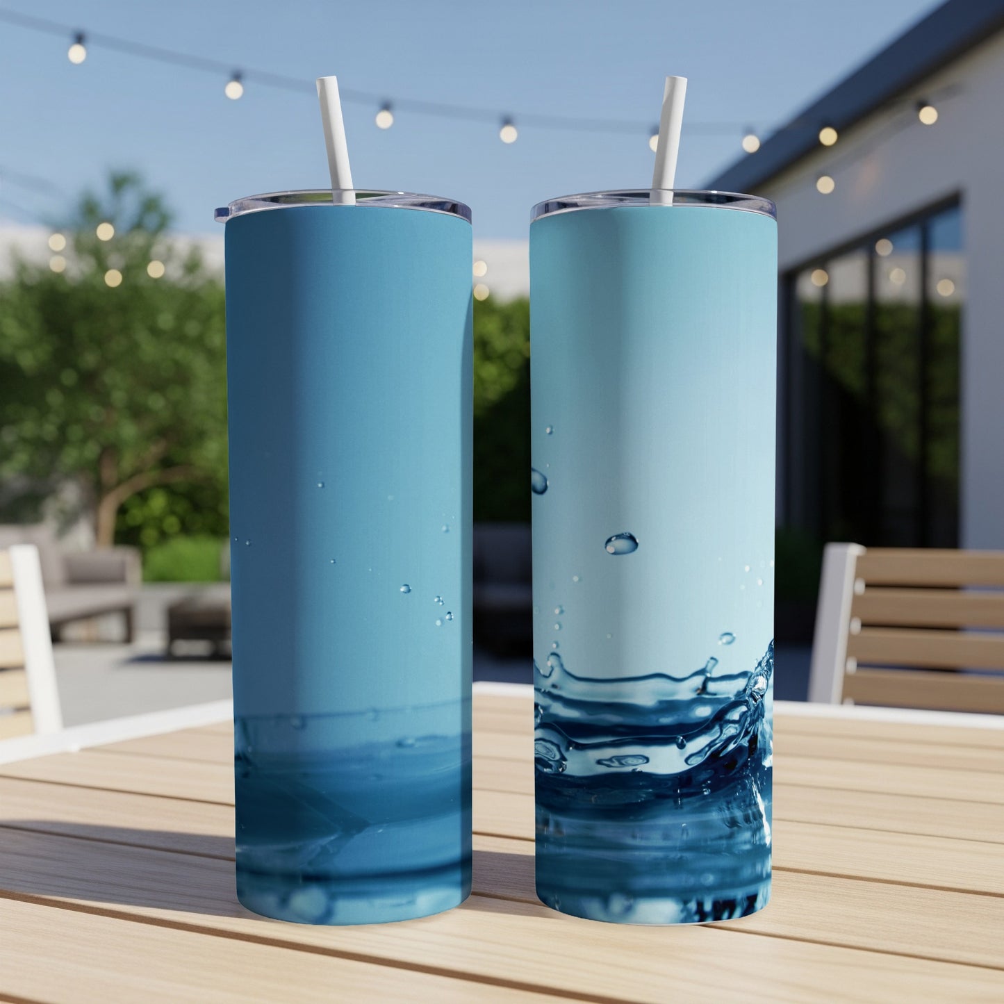 Two blue tumblers with water splash designs, on a wooden table.