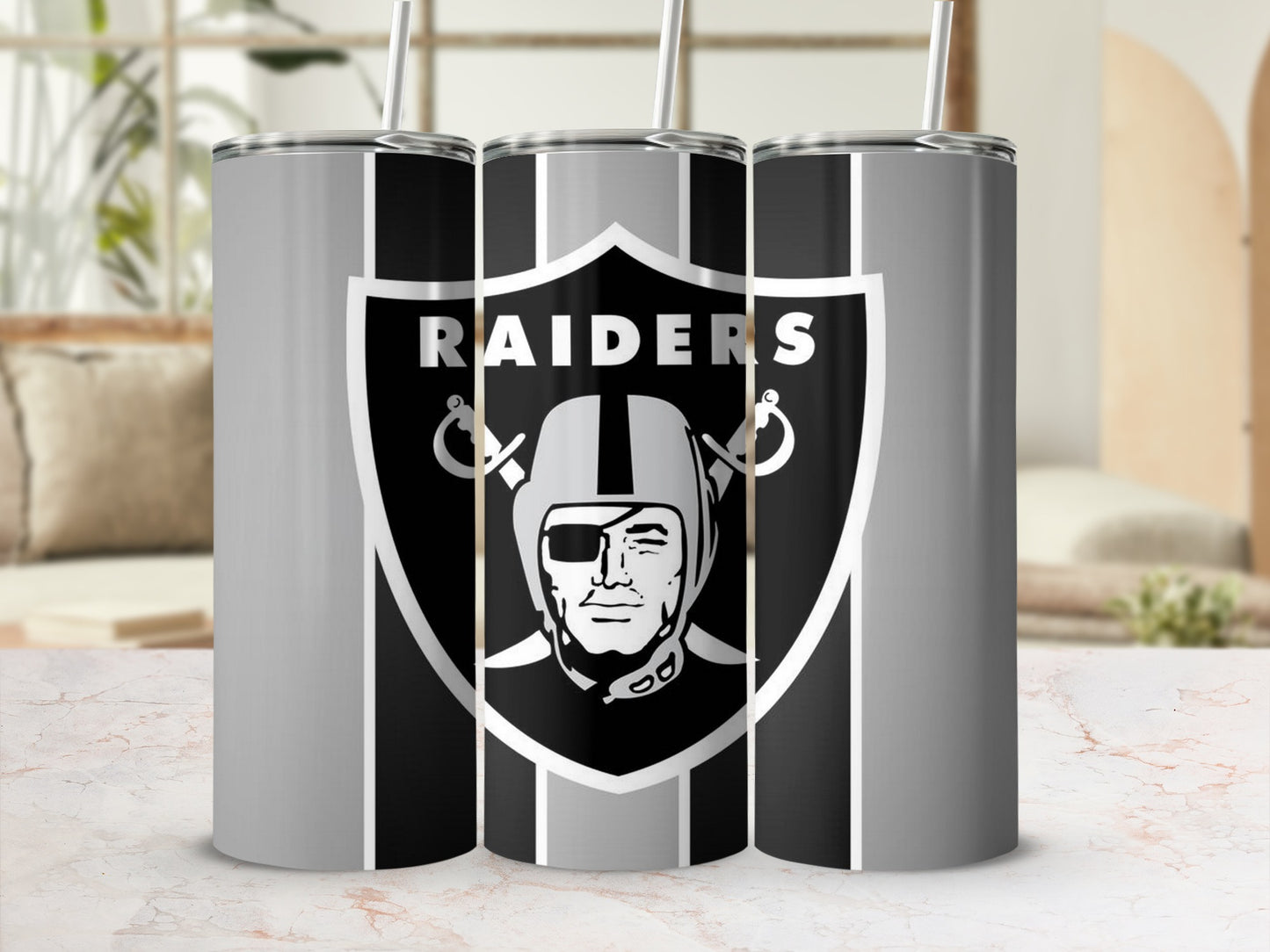 Las Vegas Raiders logo on three silver and black striped tumblers with straws.