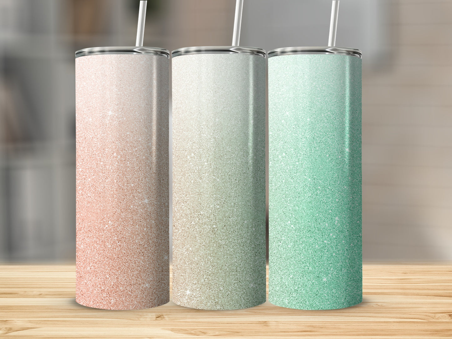 Three glitter tumblers in rose gold, beige, and mint green on a wooden surface.