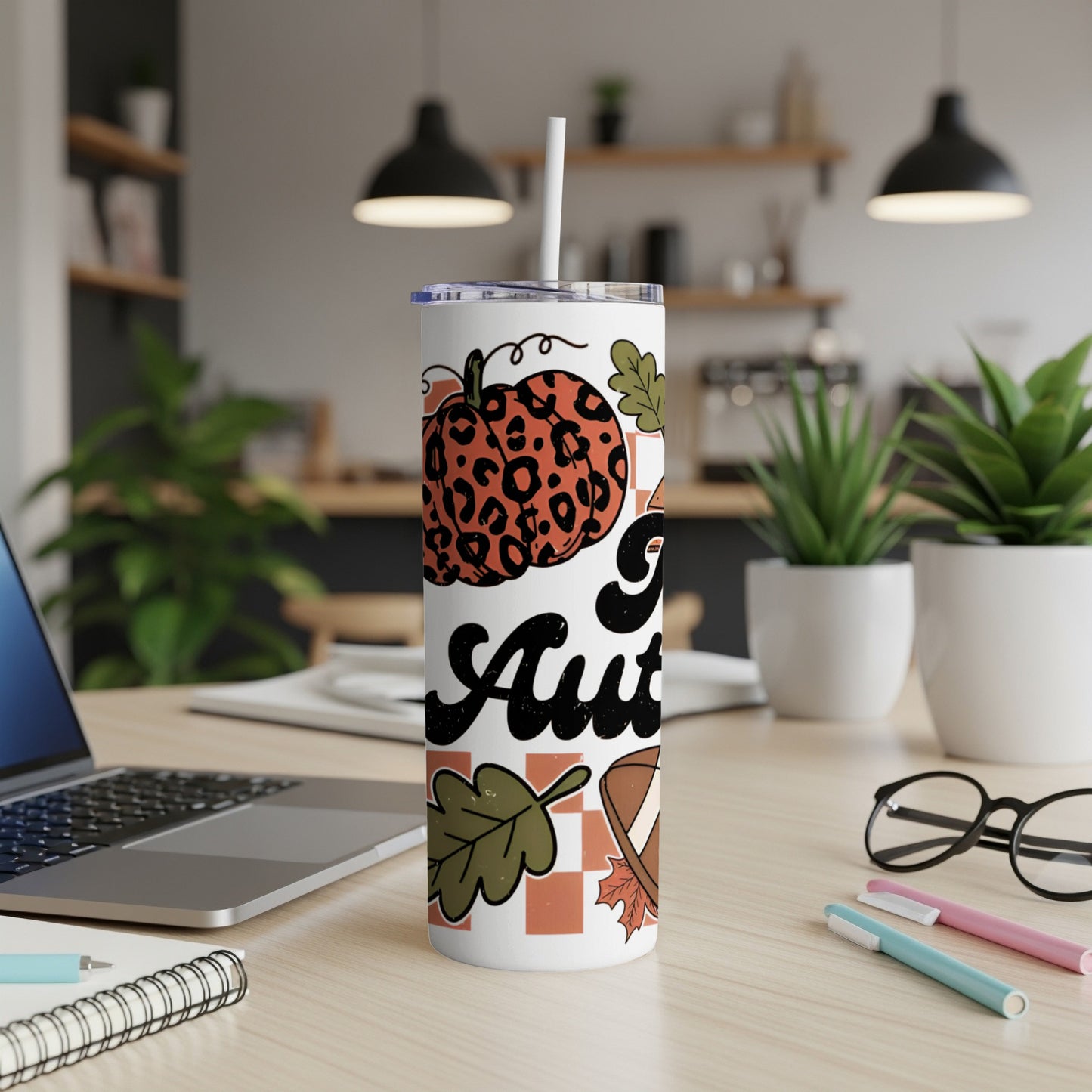 Tumbler with leopard print pumpkin and "Autumn Vibes" text on a desk.