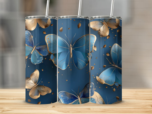 Three blue and gold butterfly tumblers with straws on a wooden surface.