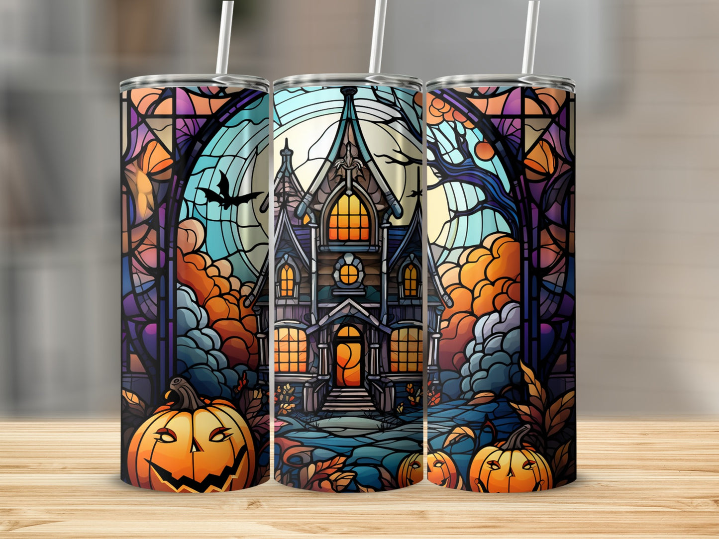 Three Halloween tumblers featuring a haunted house and jack-o'-lanterns.