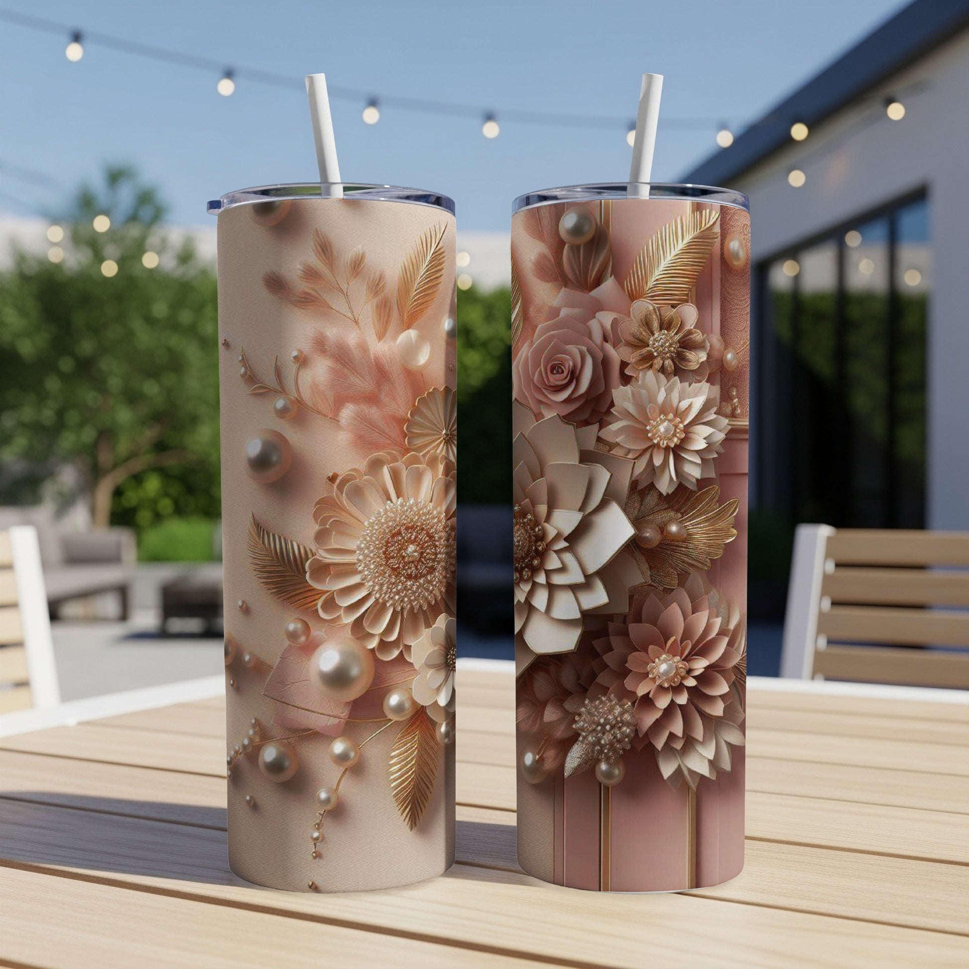 Two floral design tumblers with pearl and gold accents on a table.