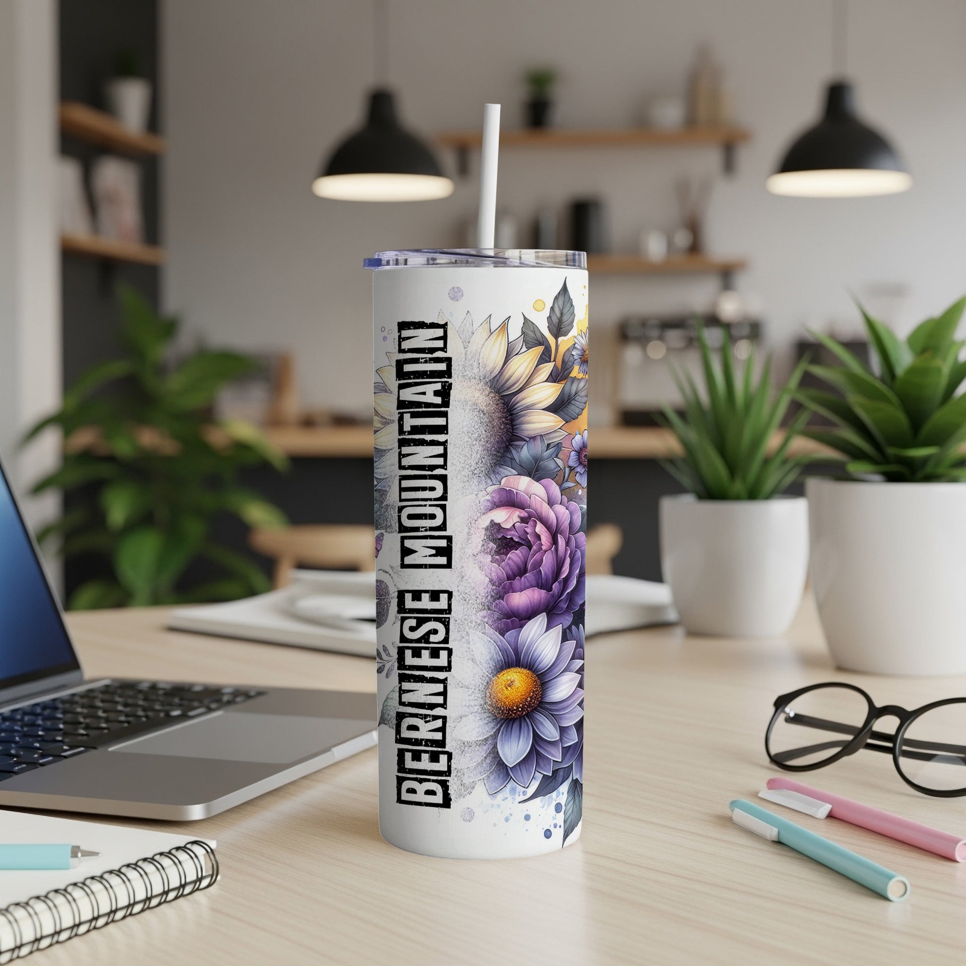 Bernese Mountain dog floral tumbler with straw on a desk.